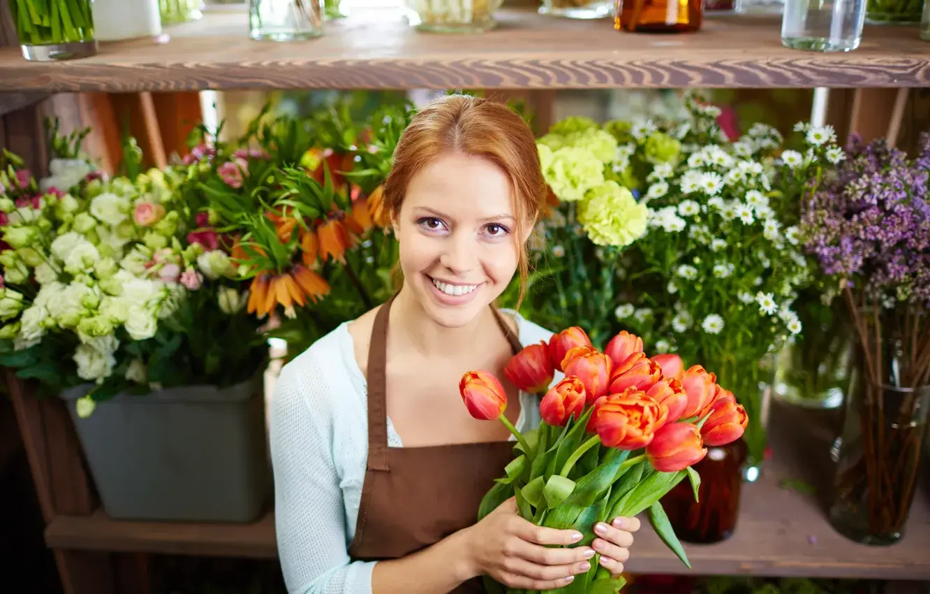 A florist smiling while holding a freshly made bouquet