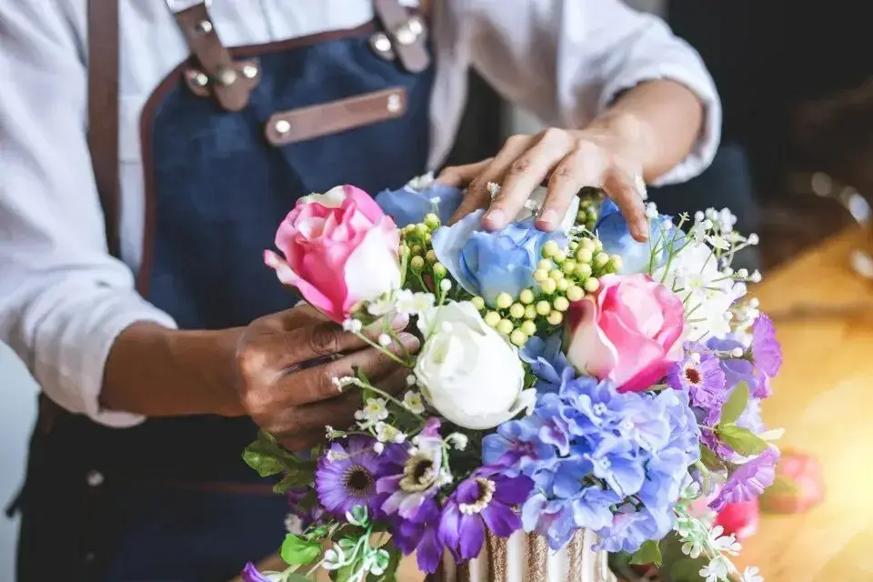 A florist's hands at work, carefully composing a bouquet